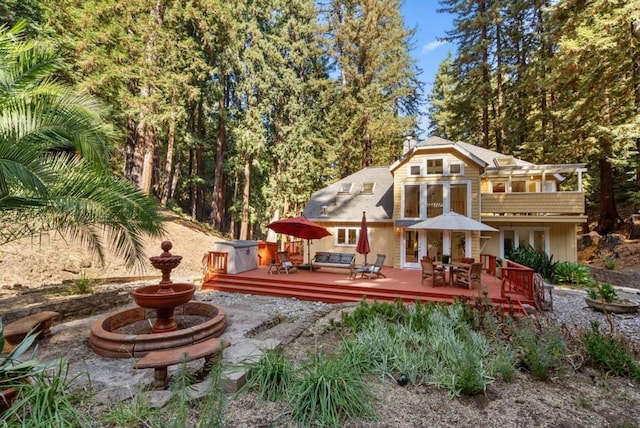 rear view of property featuring a wooden deck