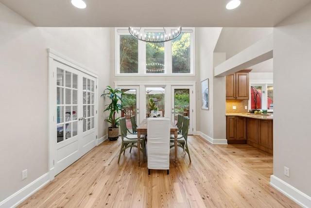 dining area featuring a chandelier, french doors, and light hardwood / wood-style flooring