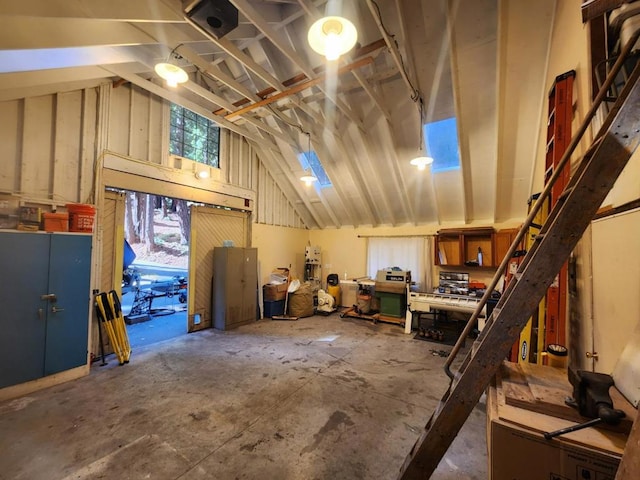 misc room featuring a workshop area, lofted ceiling, and concrete flooring