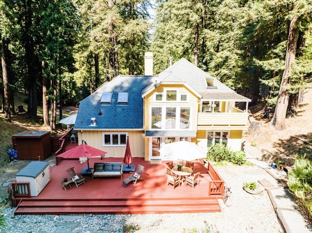 rear view of house featuring a wooden deck