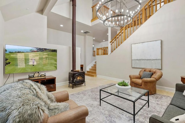 living room featuring a notable chandelier, beam ceiling, a wood stove, and high vaulted ceiling