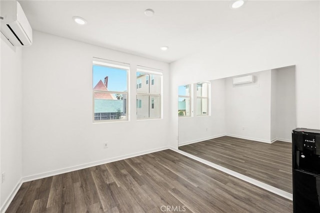 empty room with dark wood-type flooring and a wall mounted AC