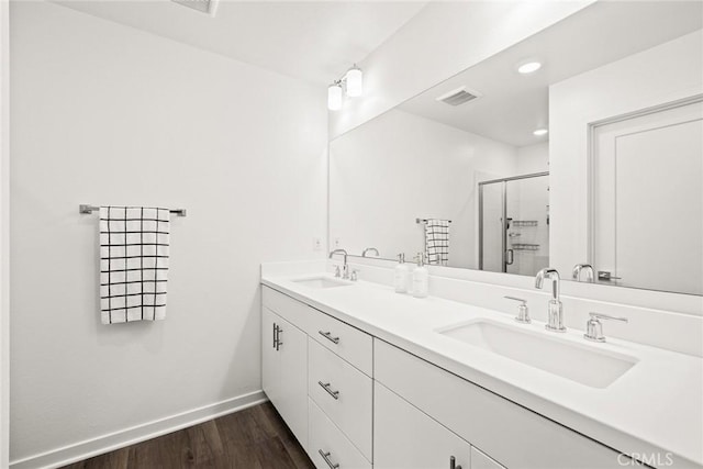 bathroom with hardwood / wood-style floors, vanity, and walk in shower