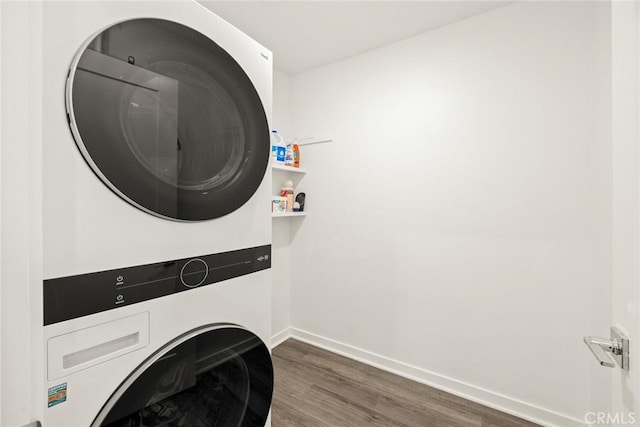 washroom with dark hardwood / wood-style floors and stacked washer and dryer