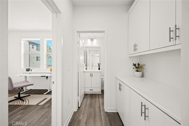 corridor featuring wood-type flooring and sink