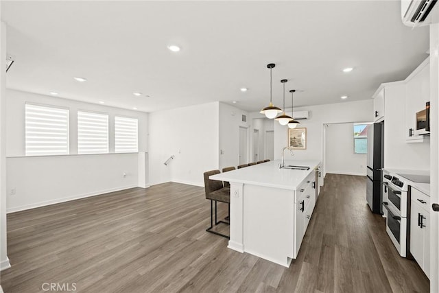 kitchen with sink, white cabinetry, a kitchen island with sink, and stainless steel appliances