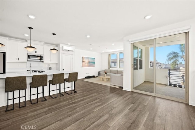 kitchen featuring white cabinets, decorative light fixtures, stainless steel appliances, and plenty of natural light