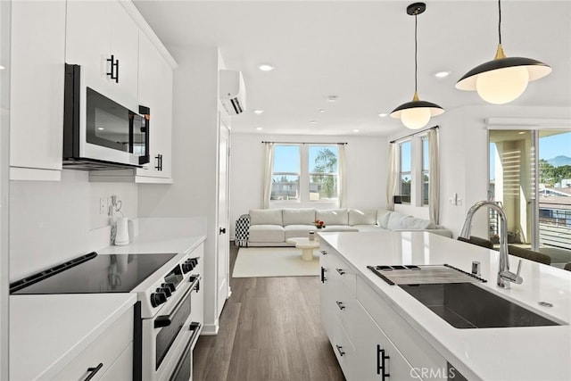 kitchen with white cabinets, sink, high quality stove, dark hardwood / wood-style flooring, and a wall unit AC