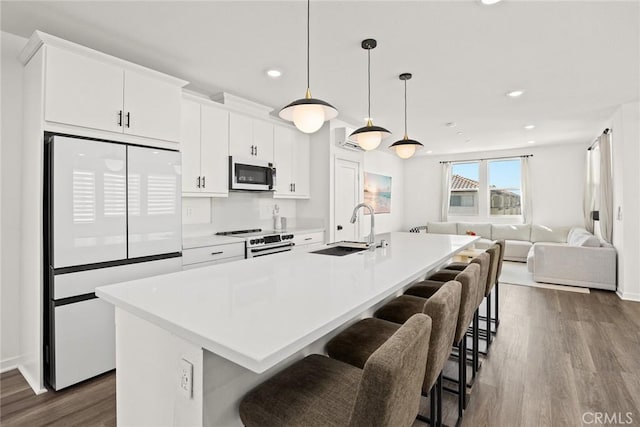 kitchen with a center island with sink, white fridge, electric range, and sink