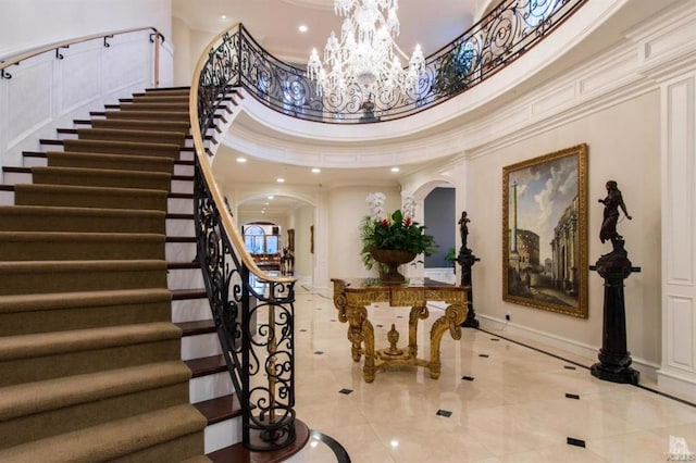 foyer with a towering ceiling and ornamental molding