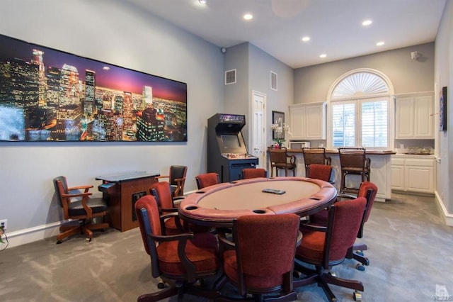 rec room with a towering ceiling and light carpet