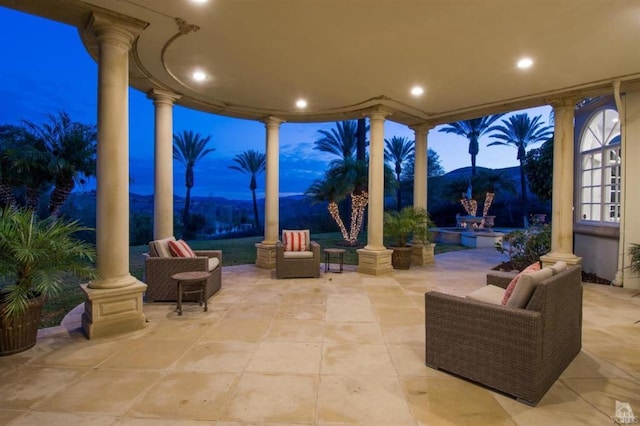 patio terrace at dusk featuring an outdoor living space and a mountain view