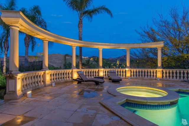 view of patio / terrace with an in ground hot tub and a mountain view