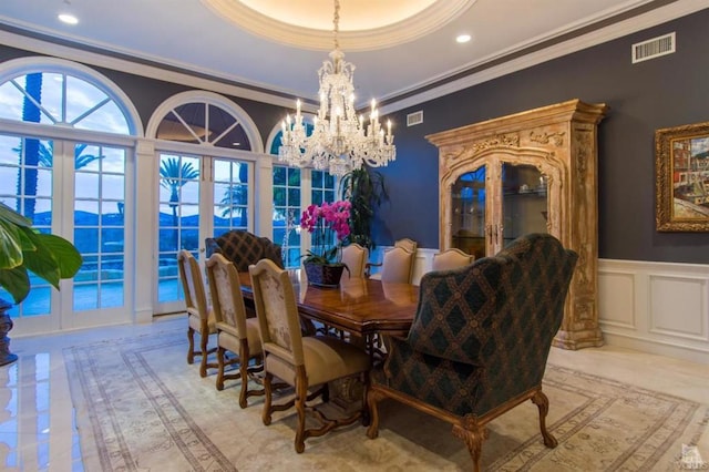 dining area with french doors, a chandelier, and ornamental molding