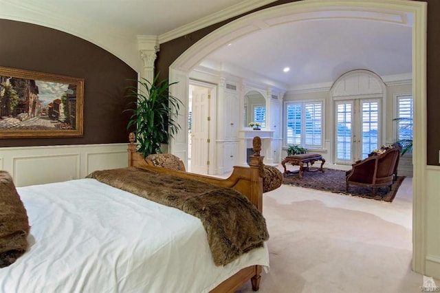 bedroom with french doors, ornamental molding, and light carpet