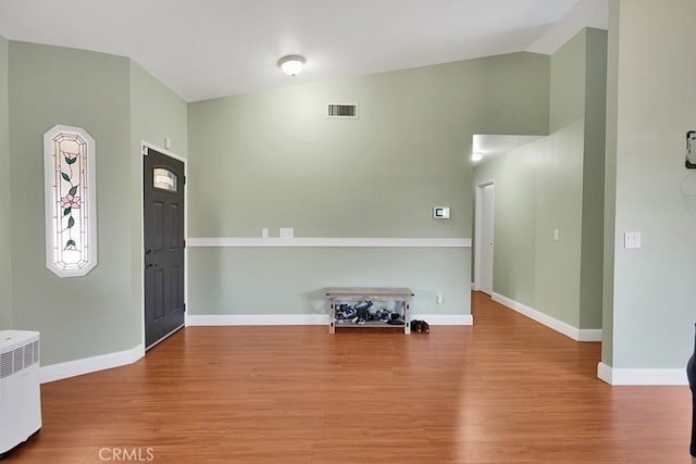 foyer featuring wood-type flooring and lofted ceiling