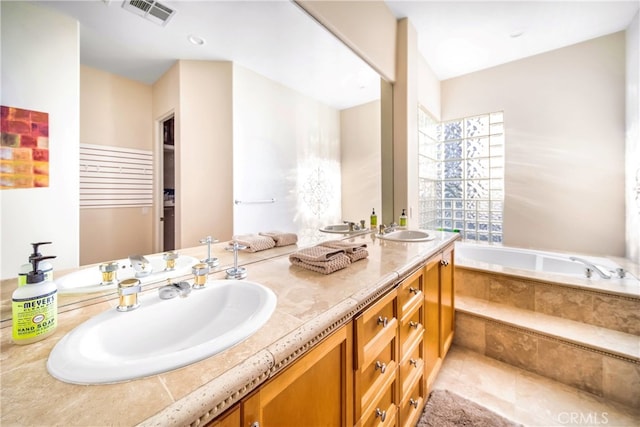 bathroom featuring vanity, tiled bath, and tile patterned floors