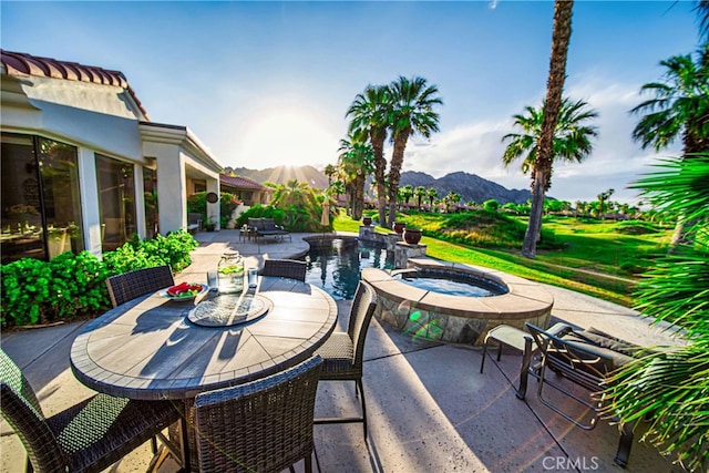 view of patio / terrace with a mountain view and an in ground hot tub