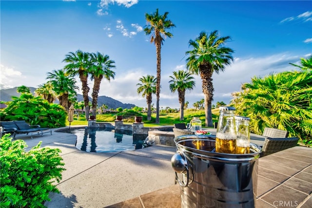 view of property's community featuring a mountain view, a patio, and a pool