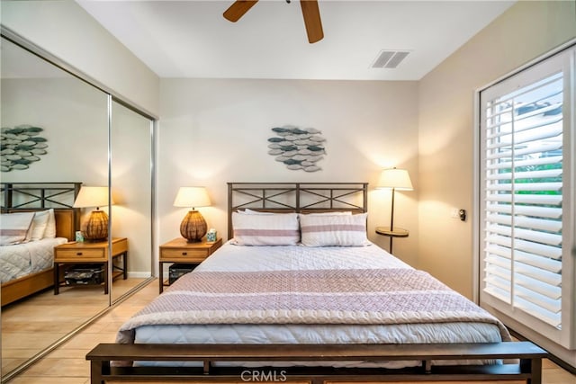 bedroom with ceiling fan, light hardwood / wood-style floors, and a closet