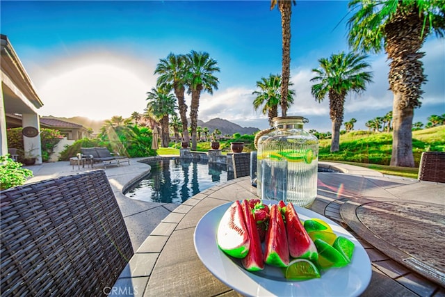 view of pool featuring a mountain view and a patio