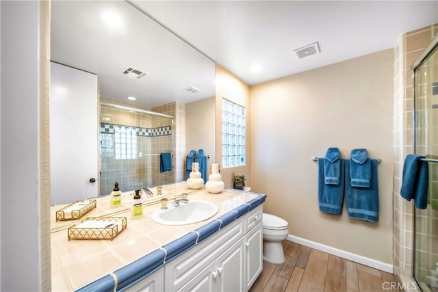 bathroom featuring toilet, a shower with door, vanity, and hardwood / wood-style flooring