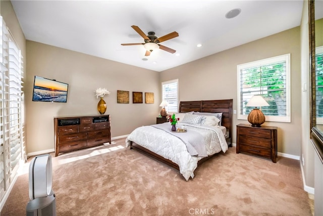 carpeted bedroom featuring multiple windows and ceiling fan