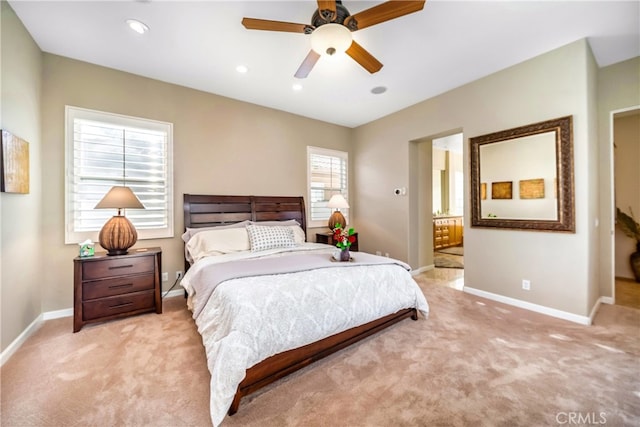 bedroom featuring ceiling fan, light colored carpet, and ensuite bathroom