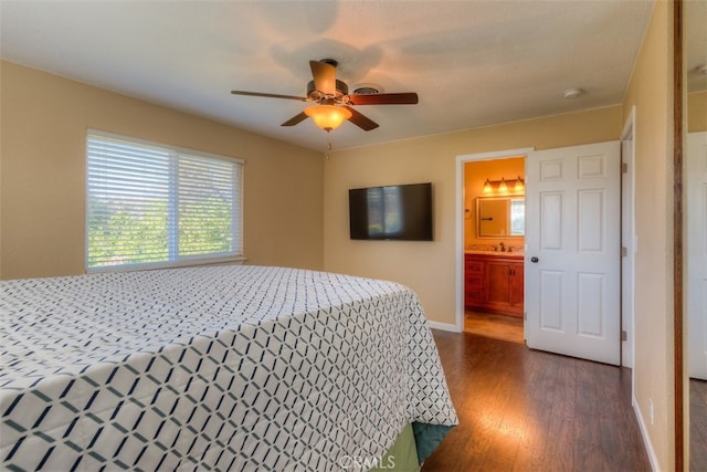 bedroom featuring dark hardwood / wood-style flooring, ceiling fan, and ensuite bath