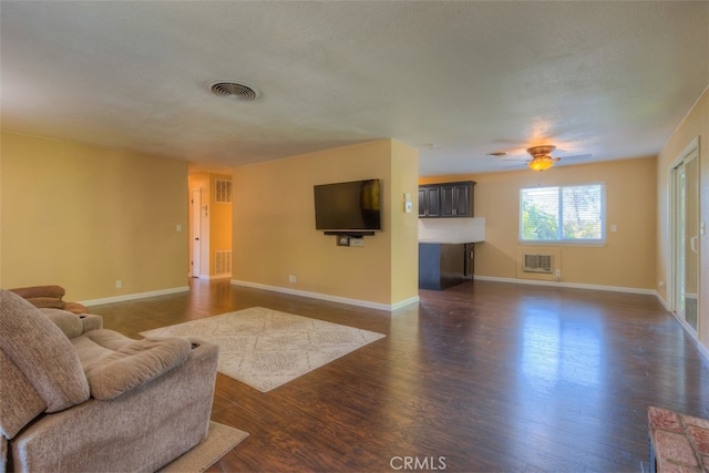 living room with ceiling fan, dark hardwood / wood-style floors, and a textured ceiling