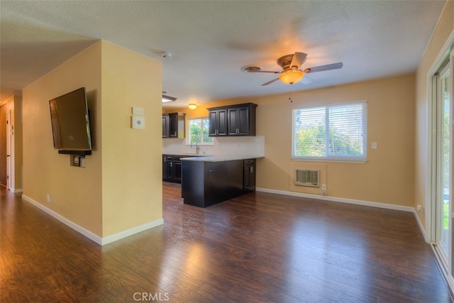 kitchen with heating unit, a textured ceiling, ceiling fan, and dark wood-type flooring