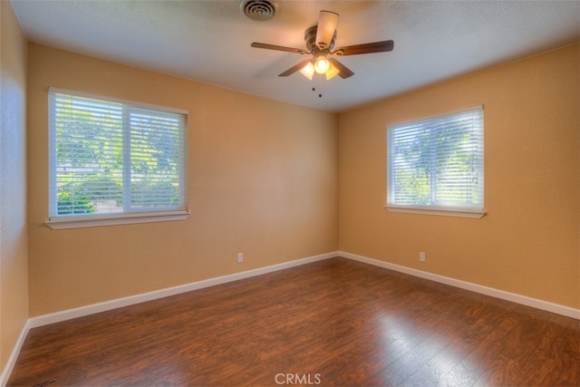 spare room featuring ceiling fan and dark wood-type flooring