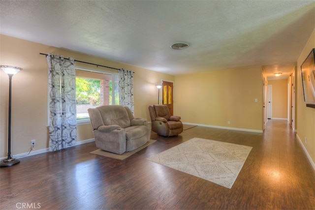 living room with a textured ceiling and dark wood-type flooring