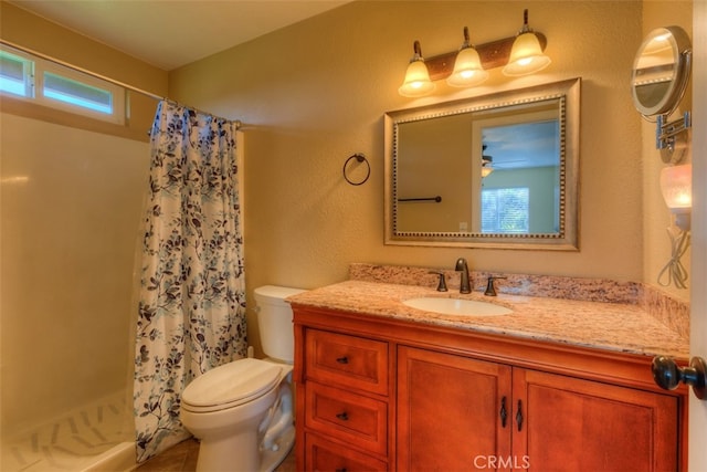 bathroom with a shower with shower curtain, vanity, toilet, and a wealth of natural light