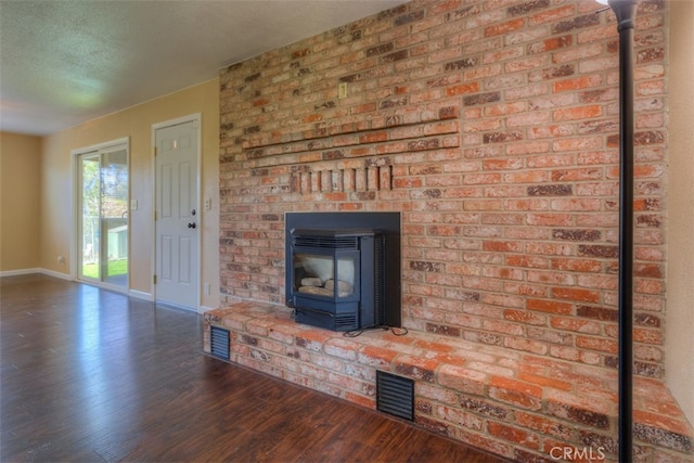 unfurnished living room with a textured ceiling and dark wood-type flooring