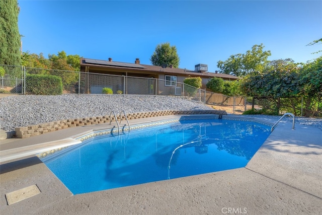 view of swimming pool with a diving board