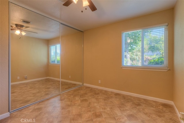 unfurnished bedroom with a closet, multiple windows, and ceiling fan