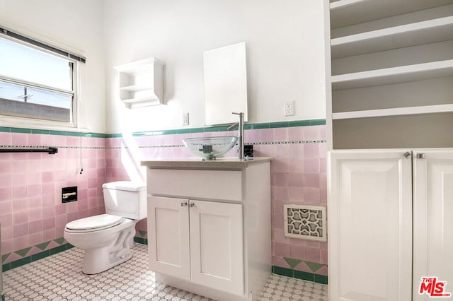 bathroom with vanity, tile walls, and toilet