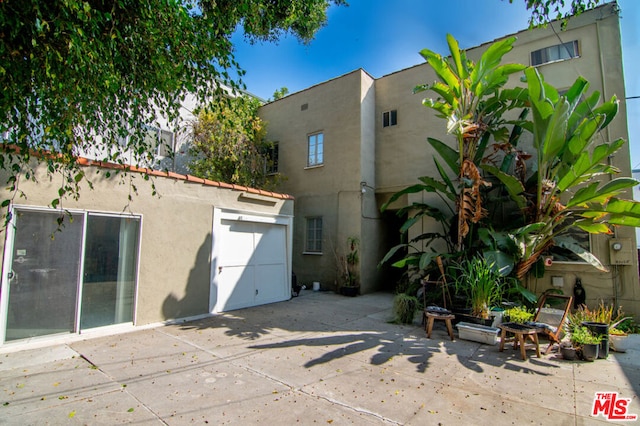 rear view of house with a patio and a garage