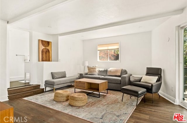 living room with beam ceiling and dark wood-type flooring