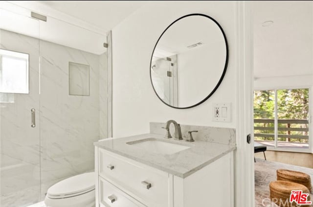 bathroom featuring vanity, toilet, and an enclosed shower