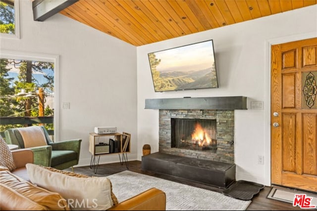 living room featuring wooden ceiling, wood-type flooring, a stone fireplace, and vaulted ceiling with beams