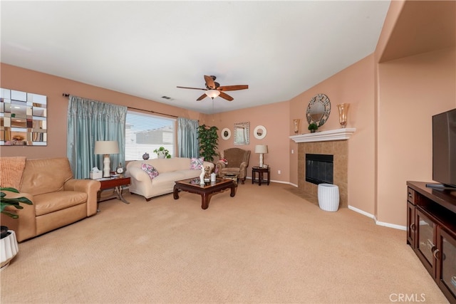 living room with a fireplace, ceiling fan, and light carpet