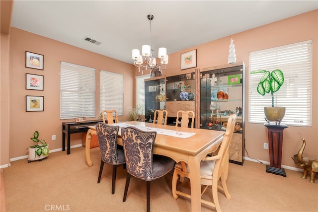 dining room featuring light carpet and an inviting chandelier