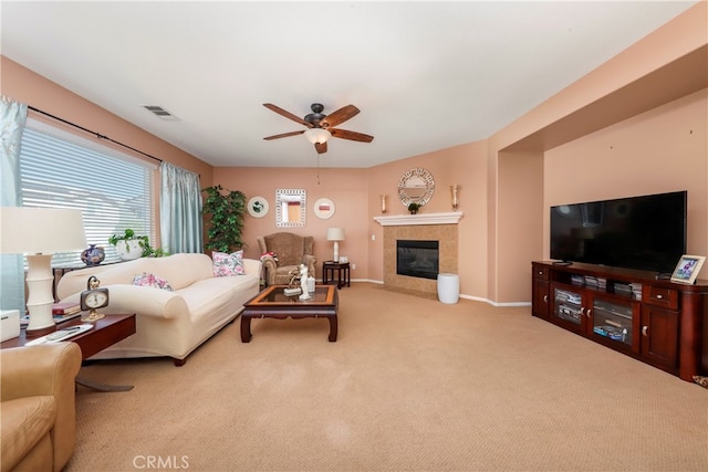 carpeted living room featuring ceiling fan and a tile fireplace