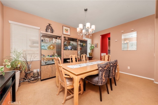 dining space with light colored carpet and an inviting chandelier