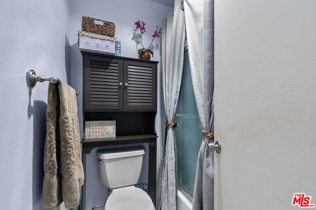 bathroom featuring toilet and a shower with shower curtain