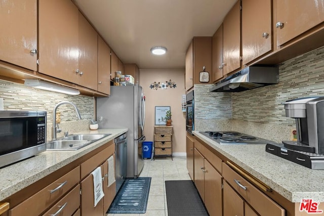 kitchen with light tile patterned floors, appliances with stainless steel finishes, sink, and tasteful backsplash