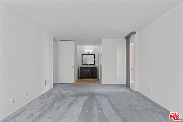 unfurnished living room with light colored carpet