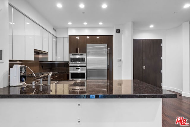 kitchen featuring white cabinetry, sink, dark hardwood / wood-style floors, dark brown cabinets, and appliances with stainless steel finishes